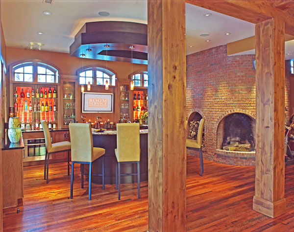 wooden floors, wooden pillars, indoor bar with bar stools, pizza oven brick walls
