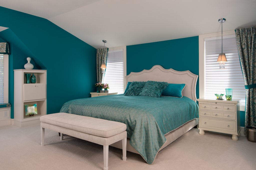 teal bedroom with overhang light, two windows, nightstand, dresser, white carpets, teal color scheme